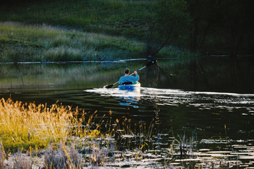 Obraz na płótnie Canvas Kayaking across pond water in fall Texas landscape.