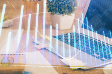 Double exposure of graph and financial info and work space with computer background. Concept of...