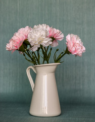 White vase with Bouquet of white and pink roses in blue background.