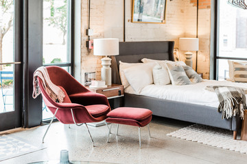 Modern velvet chair with matching stool in bedroom