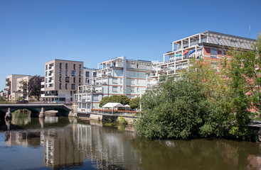 Modern residential buildings in Leipzig scene district Schleussig directly on the river Elster with...