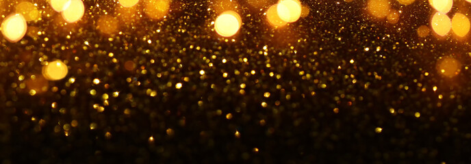 Fototapeta na wymiar background of abstract glitter lights. gold and black. de-focused. banner