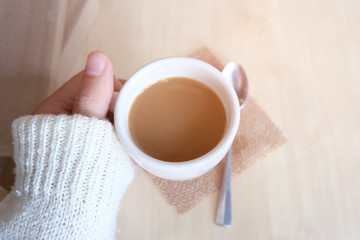 Relaxing moments, Cup of coffee and a book on wooden table in nature background, color of vintage tone and soft focus, winter morning concept.