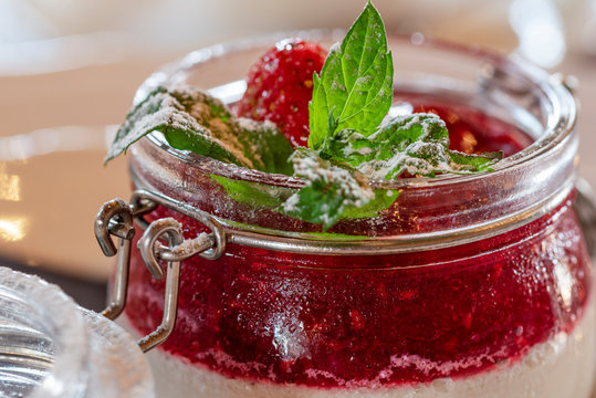 Zbliżenie na deser panna cotta z truskawką i liściem mięty