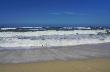 Blue sky, white waves and sunshine sandy beach at Pacific Coast, California