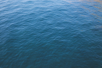 Waves on calm water in a harbor during sunset, with evening mood