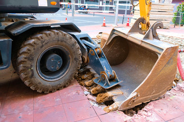 Heavy road building machinery, fore wheel, big tyre and a loader bucket.