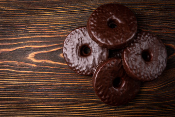 Shortbread cookies in chocolate glaze on dark wooden background.