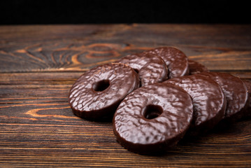 Shortbread cookies in chocolate glaze on dark wooden background.