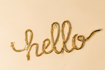 Golden Hello sign on a bright surface
