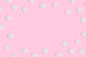 Christmas or winter composition of snowflakes on pastel pink background.