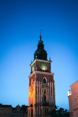 Gothic town hall tower with clock in Cracow, Poland. Summer night scene 2019 (Wieża Ratuszowa) Krakow attractions, central square, vertical photo