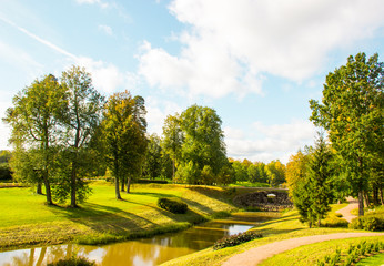 Beautiful autumn landscape - autumn trees at the bank of the river in city autumn park area in sunny day. Wonderland autumn scene with colorful trees. Nature, landscape concept. Autumn background.