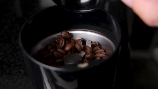 Slow Motion Video of Coffee Beans Getting Placed in the Grinder.