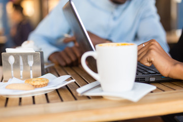 Black  African American coworkers doing digital teamwork arround a coffee cup