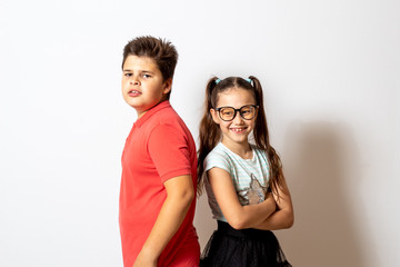 Brother and sister stand together on a white background. Happy child