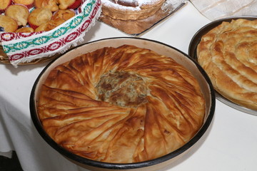 Freshly baked homemade bread arranged in traditional Bulgarian textiles. Image of some tasty Home-made bakery products. Fresh bread,brown, wheat, sliced, round, product, bagel, delicious, baking.