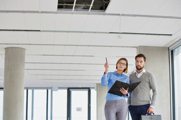 Colleagues discussing new office interiors over document