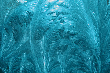 Frozen textured window glass. Winter ice frost. Winter bright blue ornament