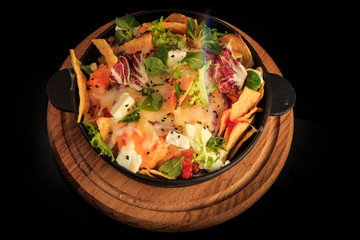 top view on originally decorated cheese and greens salad over black