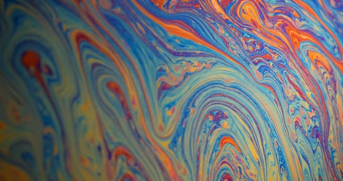 Macro shot: Surface of the soap film and the movement of rainbow streaks due to diffraction and interference of light. 4k. Slow motion