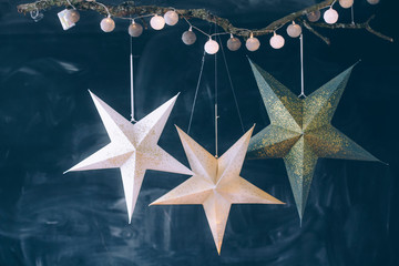 Christmas decor close-up on a black background. Three stars and a garland on a black background.