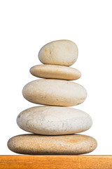 Fototapeta na wymiar Stones in stack. Balancing stones on wooden surface against white background isolated with work path.