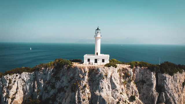 Beautiful lighthouse building at the end of a vertical cliff in Lefkada, Popular tourist destination in Greece