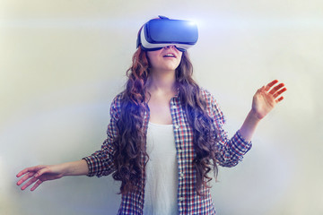 Smile young woman wearing using virtual reality VR glasses helmet headset on white background. Smartphone using with virtual reality goggles. Technology, simulation, hi-tech, videogame concept