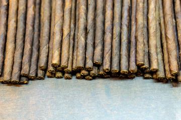 Draufsicht auf zahlreiche neu produzierte Zigarren oder Zigarillos â€“ selektive SchÃ¤rfe und reichlich Copyspace im Vordergrund