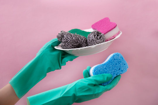 Hands In Green Protective Gloves Washing A Plate