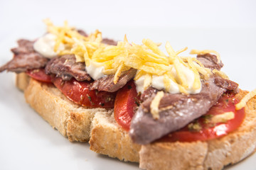 Toast of Iberian pork sirloin on a natural tomato base
