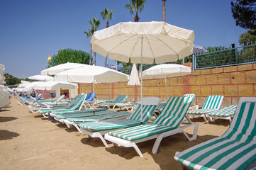 Beach loungers and umbrellas at the sunny beach in Turkey