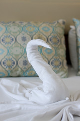 Fototapeta na wymiar Beautiful swan from bath towel on hotel bed
