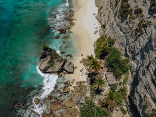 Aerial drone photo of tropical beach, sea rocks, turquoise ocean and palm trees. Atuh beach, Nusa Penida island, Bali, Indonesia. Tropical background and travel concept