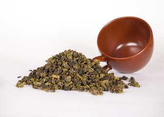 A heap of Chinese black loose leaf tea with brown cup