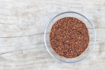 Loose tea rooibos superior in a glass cup on a wooden background