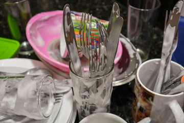 Man living alone washing accumulated dishes