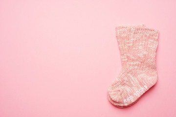 Close-up of pink melange baby socks on pink background with space for text.