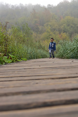 Naklejka na ściany i meble Cute boy traveling in Plitvice National Park, Croatia, in the fall