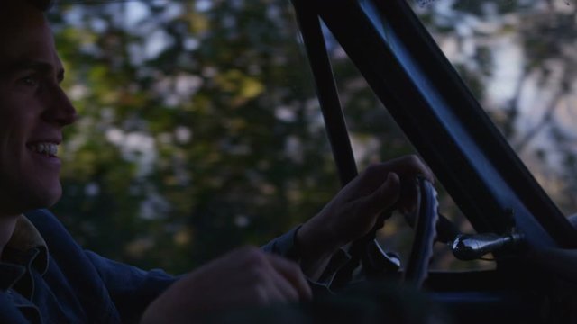 Close-up of a man driving an old pickup truck.