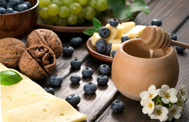 cheese, blueberries, and honey on a wooden background