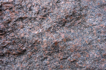 The structure of red and black granite. The texture of natural stone. Creative vintage background.