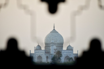 Distant view of the Taj Mahal at sunset from behind a fence