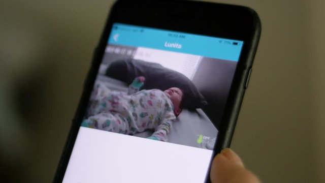 Close-up of a cellphone showing image of baby from baby monitor