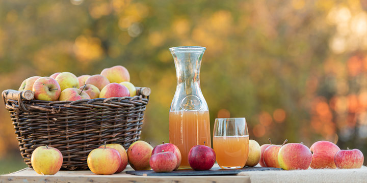 Fresh apple juice from apples in the fall after harvest, served on a table
