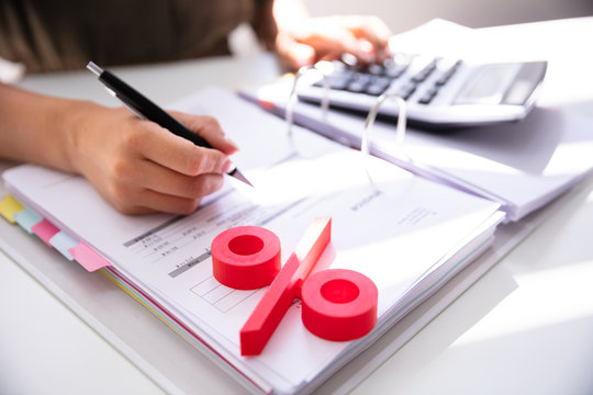 Businessperson's Hand Calculating Bill With Calculator