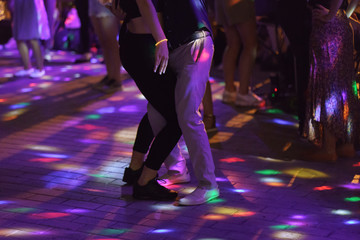 Photography of dancing people on the night party in the city street in  summer night.  Leisure, happiness and entertainment theme.