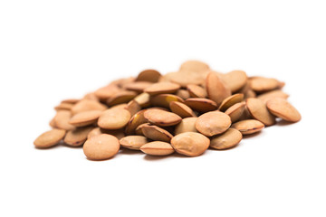 Isolated stack of uncooked lentils on white background from above.