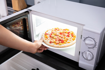 Woman Baking Pizza In Microwave Oven